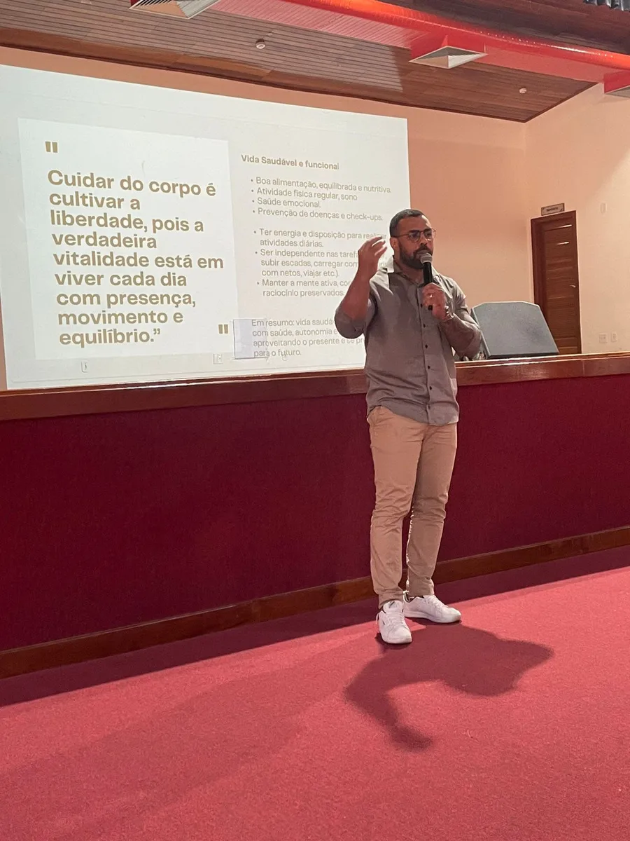 Felipe Rodrigues palestrando em auditório sobre vida saudável e funcional
